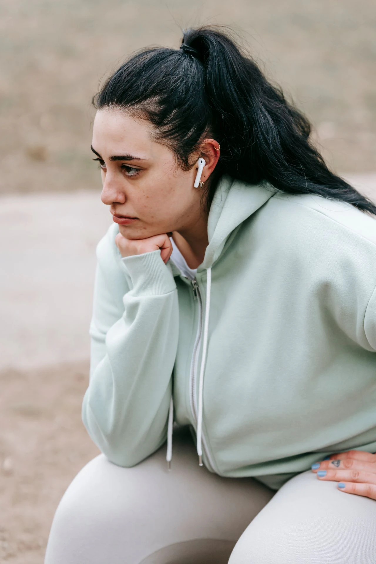 Woman experiencing discomfort from excess skin after weight loss during exercise before considering body contouring surgery.